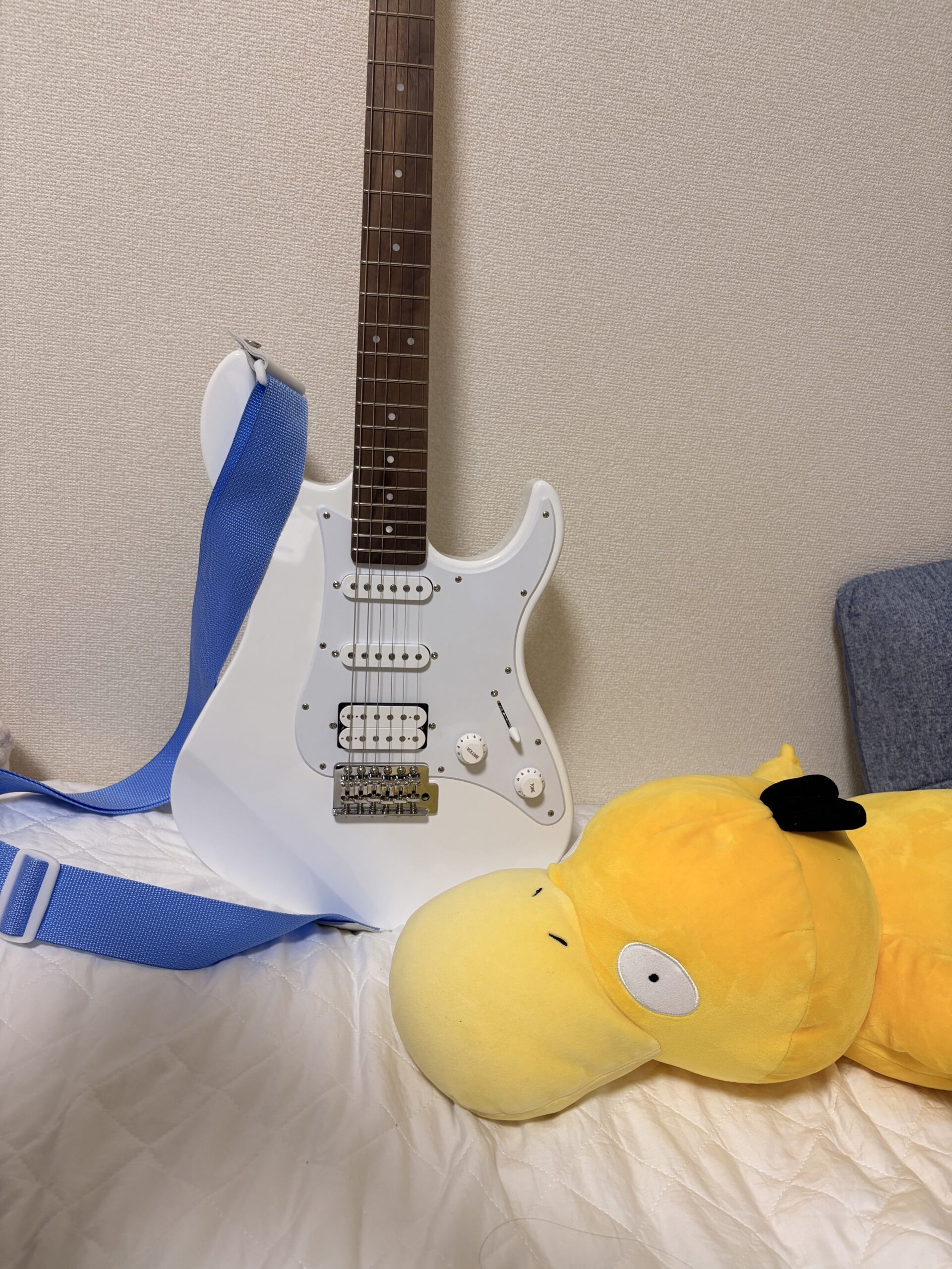 白いYAMAHA PACIFICA012と青いギターストラップ、隣にコダックのぬいぐるみ